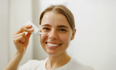 A joyful woman enjoys her skincare routine, applying products with love and radiating positivity...