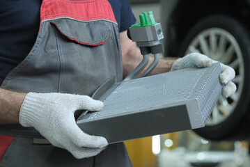 Car service. An auto mechanic prepares for the replacement of a faulty radiator and the...
