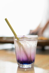 Butterfly pea with lemon juice on ice in transparent glass with lemongrass stick.