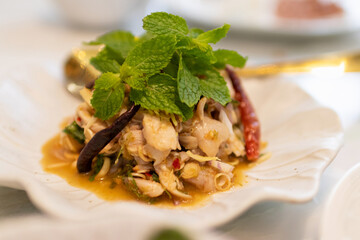 Spicy chicken salad combines Thai spicy dressing, mixed greens, herbs, and boiled breast chicken.