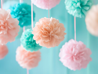 Soft pastel tissue pom-poms hang against a light blue background, creating a dreamy decoration scene.