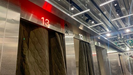 Elevator doors aligned with number 13 glowing ominously, echoing Lunar New Year vibes and...