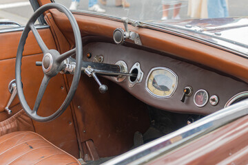 Vintage classic car dashboard with leather interior and retro steering wheel