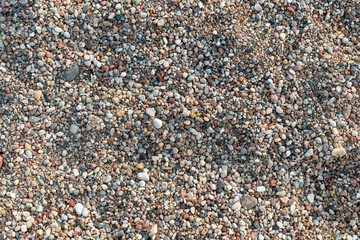 Close-up of colorful pebbles and gravel on a beach surface