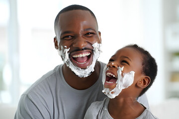 A joyful father and son share a laugh, faces covered in shaving cream