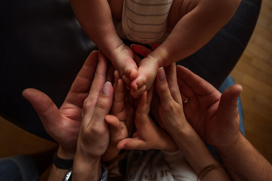 Parents holding their newborn baby's tiny feet with love and tenderness, creating a heartwarming scene that captures the essence of family bonding and emotional connection