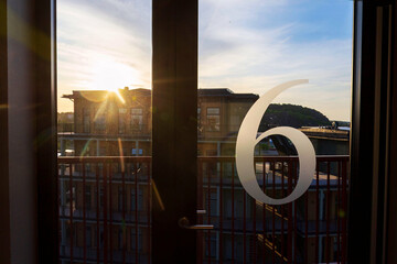 Number 6 on the glass door of an apartment building, sunny day
