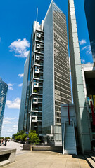Tall glass building stands in urban business district. Image is suitable for architecture, real...