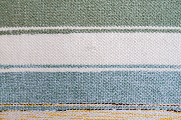Rough handmade canvas fabric with pastel striped pattern, close-up texture showing raw woven threads