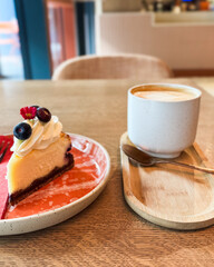 Simple dessert-coffee pairing on wooden table. Image suitable for illustrating cafe atmosphere or food and drink concepts.