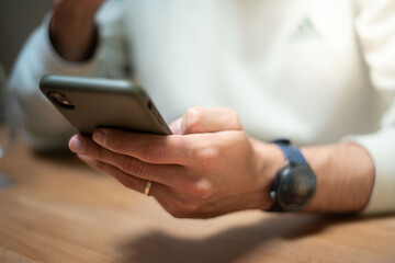Detailed view of a man's hands actively typing on a smartphone. Represents mobile communication, instant messaging, and personal connectivity in the digital age.