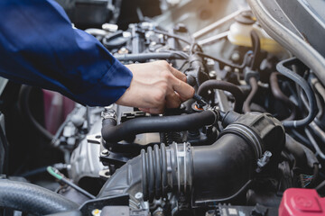 Auto check up and car service shop concept. Mechanic writing job checklist to clipboard to estimate repair quotation to client at workshop garage.