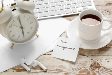 Sticky note with text TIME MANAGEMENT, cup of coffee, alarm clock, keyboard and paper sheets on...