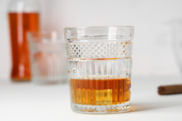Glass of cold rum on white background