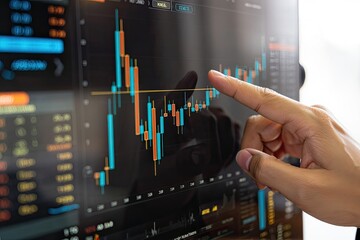 African hand touches trading chart on monitor with rising and falling financial data
