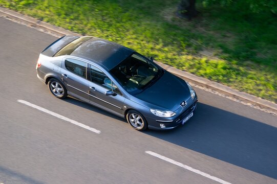 Blue French Peugeot 407 saloon car with motion blur effect at sunset