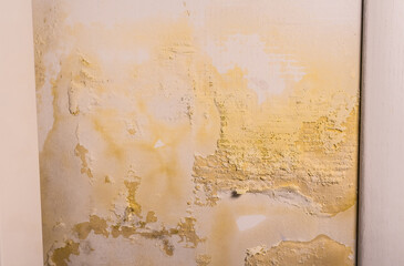 Flooded wall. The wall is peeling near the heating radiator. Pipe leak problem. Renovation concept.
