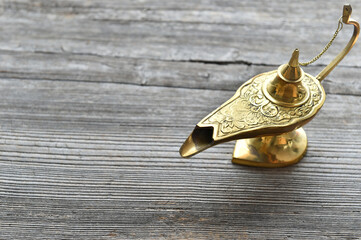 Antique brass genie lamp on rustic wooden table for magical and vintage decor