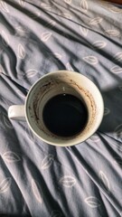 The Last Drop: A Peaceful Morning Moment.  intimate shot captures the serene aftermath of a morning coffee, with the last dark drops and coffee grounds visible at the bottom of a white ceramic mug