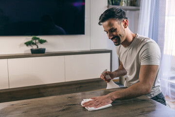 Man Cleaning Dust From Table