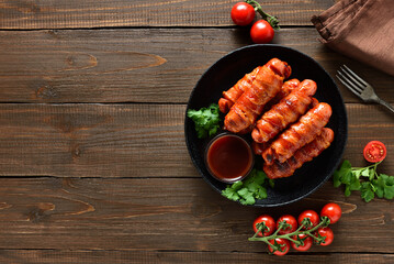 Bacon wrapped sausages with barbecue sauce