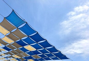 Blue and Beige Diamond Shaped Shade Sails Against Sky