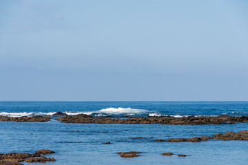 岩礁に砕ける波と紺碧の海原