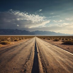 Naklejka premium Desert Road Leading into Distant Mountains under a Dramatic Sky