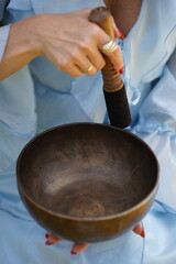 Metal bowl held by person for meditation. Image suitable for wellness, mindfulness, and relaxation content.