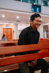 Fototapeta premium Cheerful man in church pew reflecting, showing faith and devotion