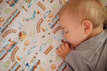 little boy sleeping in his bed. top view.