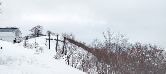 Snow mountains and hills covered with snow in winter under cloudy sky in Japan with unrecognized tourists