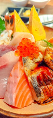 Kaisen don (Rice bowl with sashimi) in Japanese style meal, raw tuna, raw salmon, raw scallop, sweet egg, salmon roe, on sushi sour rice in Japanese restaurant
