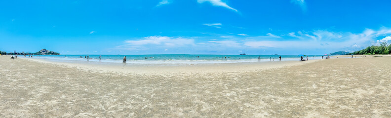 Blue cloudy sky with sea, sand beach, and tree nearby in summer of Thailand