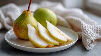Sliced and Whole Pears on a Plate with a Textured Cloth Background