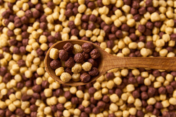 corn balls and chocolate corn balls in a wooden spoon of above corn balls as background. Copy space for text.