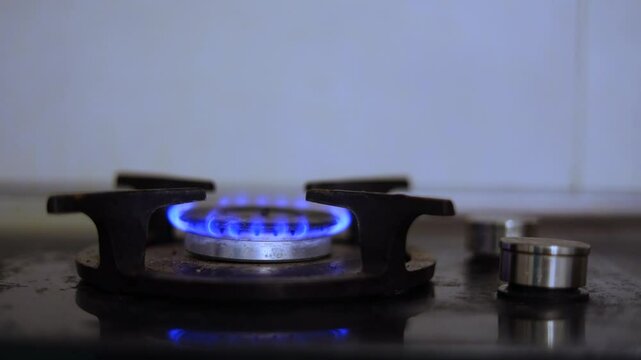 Horizontal 4K looped video. Loop. Blue combustible or natural gas burns endlessly on kitchen stove. Gasification of country, restrictions, payment of utilities, energy crisis, rising fuel prices. Fire