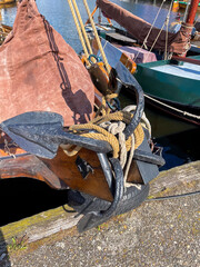 Alter Anker mit 4 Flunken mit Seilen, Tauen und Ankerkette am Bug eines Holzschiffes