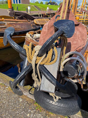 Alter Anker mit 4 Flunken mit Seilen, Tauen und Ankerkette am Bug eines Holzschiffes