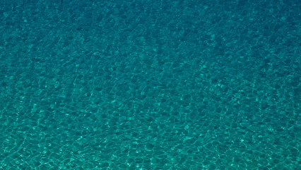 Transparent turquoise water surface gently rippling under the summer sun in Tropea, Calabria,...
