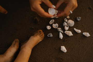Tender beach moments between parent and child — collecting seashells, walking barefoot on sand, and enjoying a calm seaside sunset.