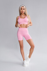 Fitness woman. Athletic girl on the gray background