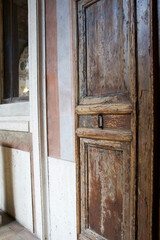 Rustic wooden door with intricate details and weathered texture in historic building interior