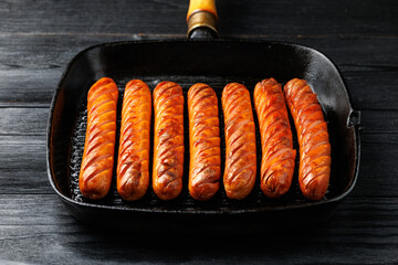 Grilled sausages served in a rustic cast iron pan