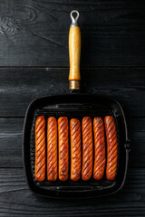 Grilled sausages served in a rustic cast iron pan