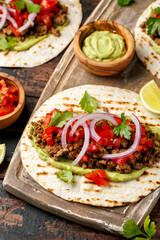 Tasty Beef Tacos with guacamole, tomato, onion and sauce. Tortilla Fast Food.