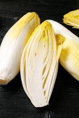 Raw chicory or endives salad roots on wooden background