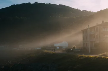 Pilgrims with backpacks walking along Camino Way during inspiring early morning on famous Camino de Santiago illuminated by magical sunrise rays, peaceful moment of spiritual journey and nature beauty
