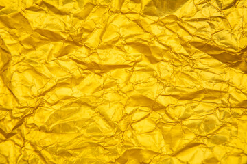 Golden yellow background with heavy wrinkles. Golden yellow recycled kraft paper texture as background.
