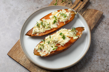 Baked sweet potatoes with ricotta and fresh herbs. Healthy and vegan food